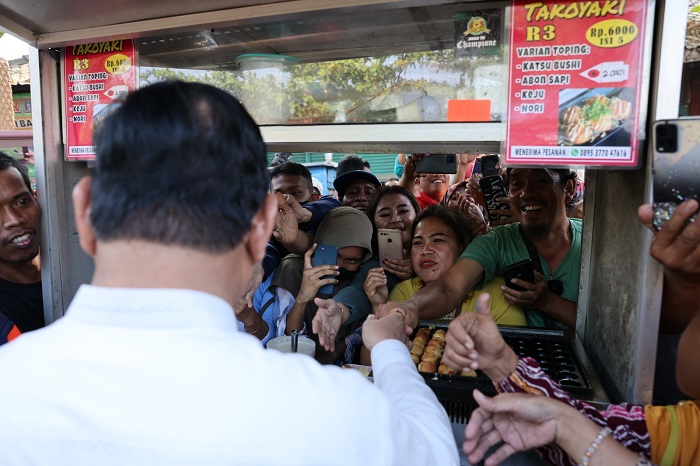 Menteri Pertahanan Prabowo Subianto menunggu giliran jajan takoyaki di tengah suasana heboh masyarakat menyambut kedatangannya. (Dok. Tim Media Prabowo Subianto)